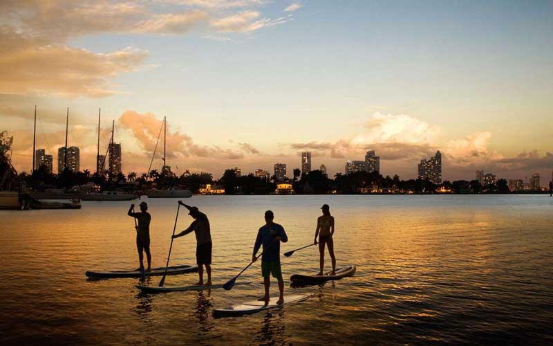 Amura,AmuraWorld,AmuraYachts, La emoción del paddleboard al atardecer en las aguas de Miami y Miami Beach.