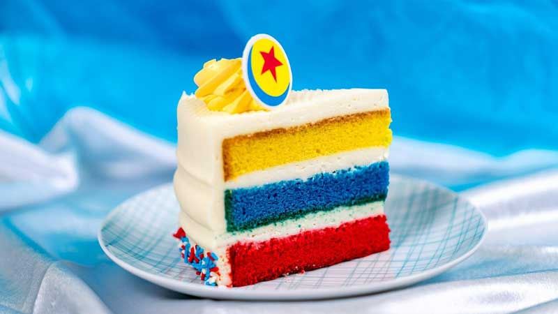 Amura,AmuraWorld,AmuraYachts, El pastel Pixar Fest: capas de bizcocho sabor en colores vainilla amarillo, azul y rojo con glaseado de queso crema y decoración de Pixar Ball de chocolate.