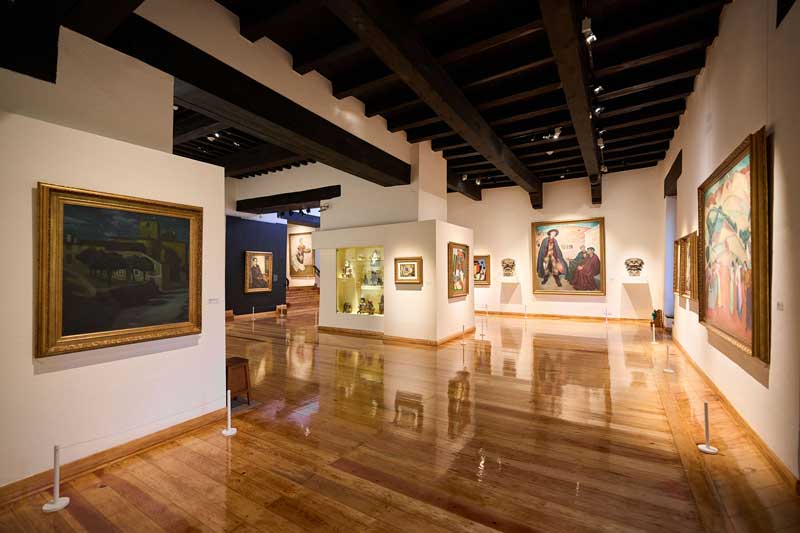 Amura,AmuraWorld,AmuraYachts, Un espacio de galería en el Museo Dolores Olmedo, que presenta obras de Diego Rivera y una selección de objetos precolombinos. En la pared de la izquierda se exhibe <em><i>Escena nocturna en Ávila</i></em>, obra de Rivera de 1907; en la pared del fondo, <em><i>Las afueras de Toledo</i></em>, de 1912. Foto: Museo Dolores Olmedo, 2026. Obras de arte: © 2026 Banco de México Diego Rivera & Frida Kahlo Museums Trust, México, DF/Artists Rights Society (ARS), Nueva York.